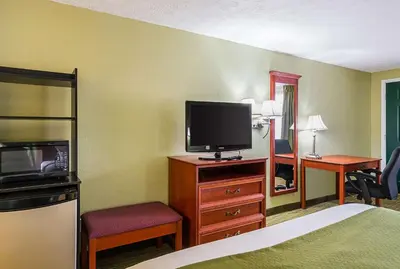 a hotel room with a bed and a flat screen tv at Quality Inn Weston in Weston
