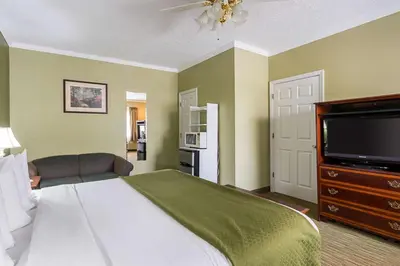 a bedroom with a bed and a flat screen tv at Quality Inn Weston in Weston