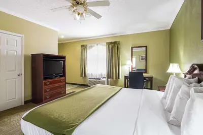 a bedroom with a large bed and a flat screen tv at Quality Inn Weston in Weston