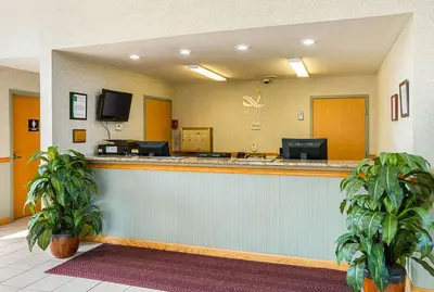 a hotel lobby with a reception counter with two plants at Quality Inn Weston in Weston