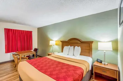 a hotel room with a large bed and a desk at Econo Lodge Huntington - Barboursville University Area in Huntington