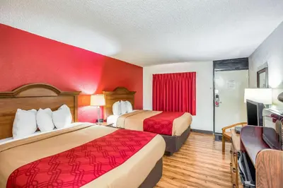 a hotel room with two beds and a red wall at Econo Lodge Huntington - Barboursville University Area in Huntington