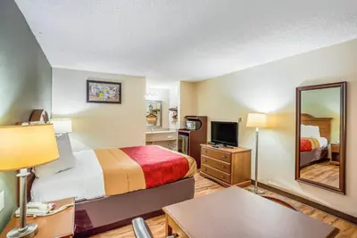 a hotel room with a bed and a mirror at Econo Lodge Huntington - Barboursville University Area in Huntington