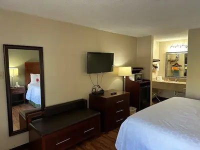 a hotel room with a bed and a mirror at Econo Lodge Huntington - Barboursville University Area in Huntington