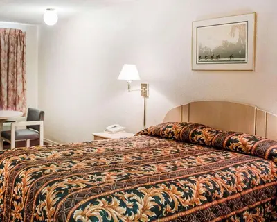 a hotel room with a bed and a table and a chair at Rodeway Inn Findlay University Area in Findlay