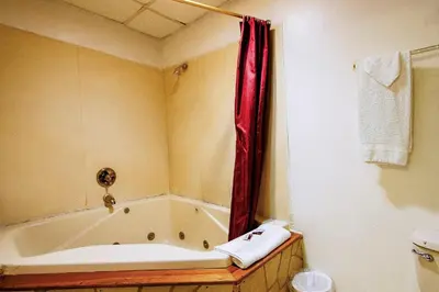 a bathroom with a tub and a red shower curtain at OYO Hotel Chapmanville Inn, WV - Hwy 119 in Chapmanville