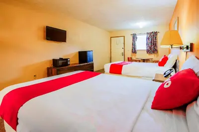 a hotel room with two beds and a television at OYO Hotel Chapmanville Inn, WV - Hwy 119 in Chapmanville