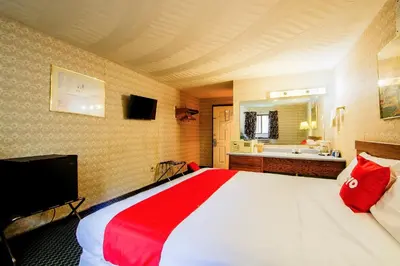 a bedroom with a large bed and a bathroom at OYO Hotel Chapmanville Inn, WV - Hwy 119 in Chapmanville