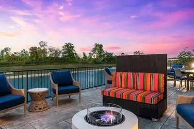 a patio with chairs and a fire pit on a deck at Home2 Suites By Hilton Fort Wayne North in Sunnybrook Acres
