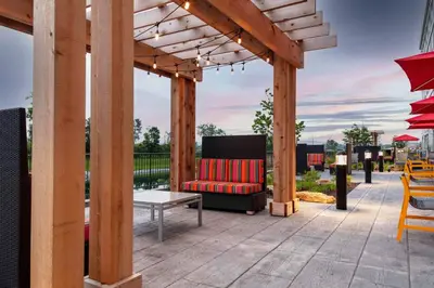a wooden pergola with a couch on a patio at Home2 Suites By Hilton Fort Wayne North in Sunnybrook Acres