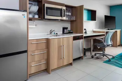 a kitchen with a sink and a refrigerator and a desk at Home2 Suites By Hilton Fort Wayne North in Sunnybrook Acres