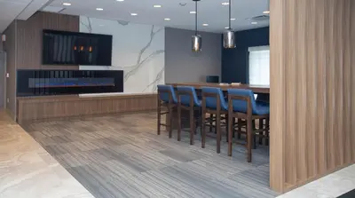 a dining room with a bar with blue chairs at Candlewood Suites - Cleveland South - Independence by IHG in Independence