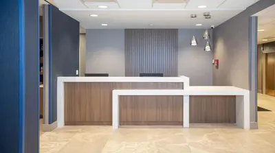 an office lobby with a white counter and blue walls at Candlewood Suites - Cleveland South - Independence by IHG in Independence