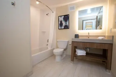 a bathroom with a toilet and a sink and a tub at Candlewood Suites - Cleveland South - Independence by IHG in Independence