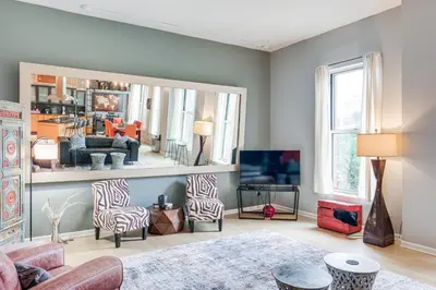 a living room with a large mirror on the wall at Dtwn Cleveland Loft-Style Condo Walk to Stadiums! in Cleveland