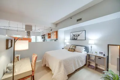a bedroom with a bed and a dining room at Dtwn Cleveland Loft-Style Condo Walk to Stadiums! in Cleveland