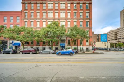 a parking lot with cars parked in front of a building at Dtwn Cleveland Loft-Style Condo Walk to Stadiums! in Cleveland