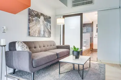 a living room with a couch and a table at Dtwn Cleveland Loft-Style Condo Walk to Stadiums! in Cleveland