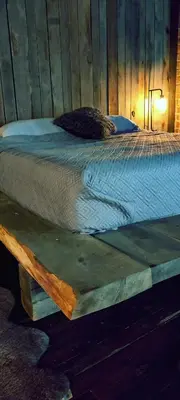 a bed in a room with a wooden wall at Hocking Hills Rusty Lofts in Logan
