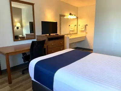 a hotel room with a bed and a desk and a mirror at Cedar Cove in Sandusky