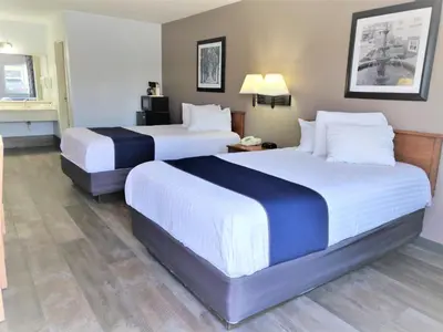 two beds in a hotel room with white and blue sheets at Cedar Cove in Sandusky