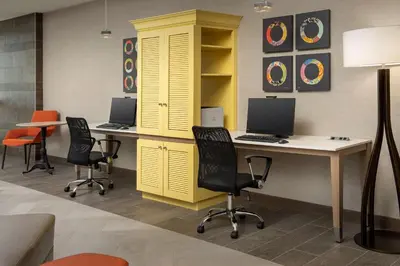 an office with two desks and a yellow cabinet with two computers at Home2 Suites By Hilton Marysville in Marysville