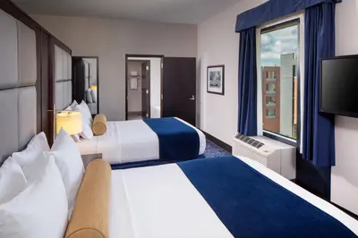 a hotel room with two beds and a flat screen tv at Kent State University Hotel and Conference Center in Kent