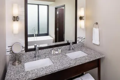a bathroom with two sinks and a large mirror at Kent State University Hotel and Conference Center in Kent