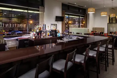 a bar in a restaurant with chairs around it at Kent State University Hotel and Conference Center in Kent