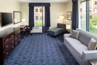 a living room with a couch and a tv at Kent State University Hotel and Conference Center in Kent