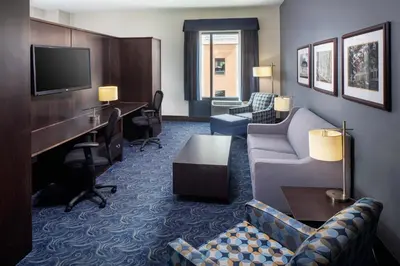 a hotel room with a couch and a desk at Kent State University Hotel and Conference Center in Kent