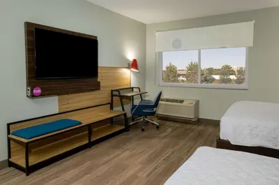 a hotel room with a bedroom with a desk and a tv at Tru By Hilton Grove City Columbus in Grove City