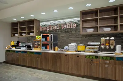 a kitchen with wooden cabinets and a counter top at Home2 Suites By Hilton Grove City Columbus in Grove City