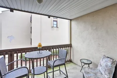 a patio with a table and chairs on a balcony at The Shores Condo with Beach Access Less Than 2 Mi to Dtwn! in Port Clinton