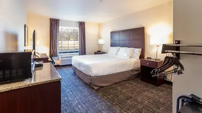 a hotel room with a bed and a television at Cobblestone Inn & Suites - Brookville in Brookville