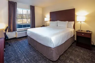 a hotel room with a large bed and a window at Cobblestone Inn & Suites - Brookville in Brookville