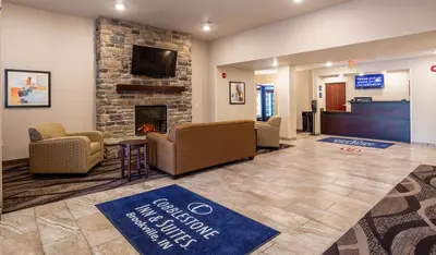 a lobby with a waiting room with a fireplace at Cobblestone Inn & Suites - Brookville in Brookville
