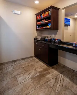 a hotel room with a counter and a drink station at Cobblestone Inn & Suites - Brookville in Brookville