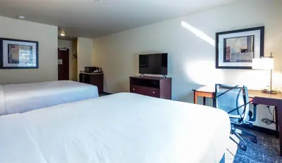 a hotel room with two beds and a desk at Cobblestone Inn & Suites - Brookville in Brookville
