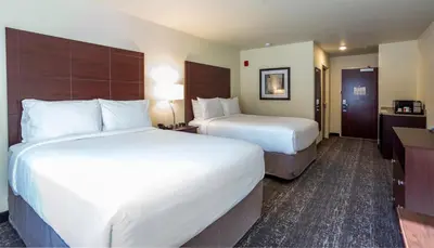 a hotel room with two beds and a desk at Cobblestone Inn & Suites - Brookville in Brookville