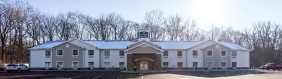 a large white building with a clock tower on top at Cobblestone Inn & Suites - Brookville in Brookville
