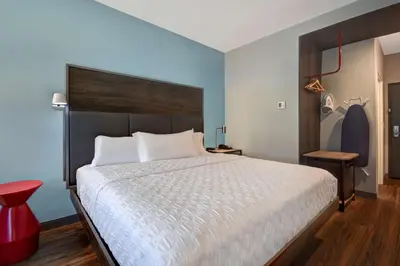 a bedroom with a large bed and a red stool at Tru By Hilton Auburn, In in Auburn