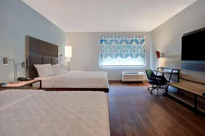 a hotel room with two beds and a flat screen tv at Tru By Hilton Auburn, In in Auburn