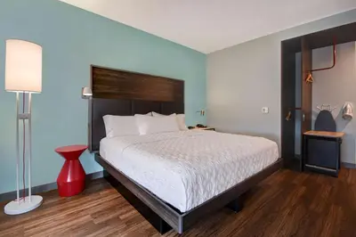 a bedroom with a large bed and a red lamp at Tru By Hilton Auburn, In in Auburn