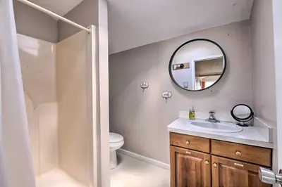 a bathroom with a toilet and a sink and a mirror at Loft Unplugged with Outdoor Space in Amish Country! in Burton