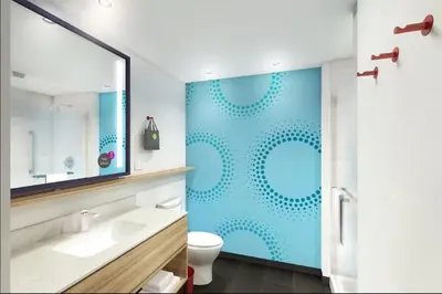 a bathroom with a toilet and a blue wall at Tru by Hilton Perrysburg Toledo in Rossford