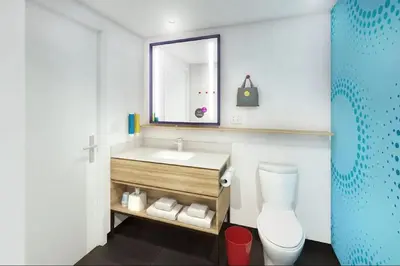 a bathroom with a sink and a toilet and a mirror at Tru by Hilton Perrysburg Toledo in Rossford