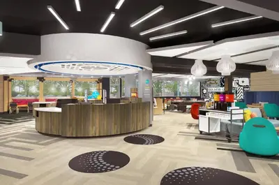 a lobby with a waiting area with chairs and tables at Tru by Hilton Perrysburg Toledo in Rossford