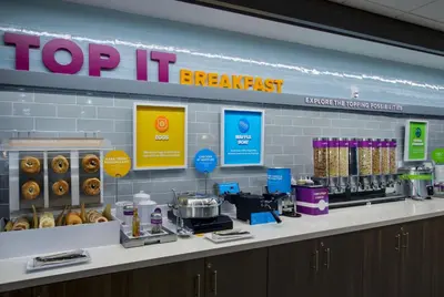a donut shop counter with a top it breakfast sign at Tru By Hilton Columbus Airport in Columbus