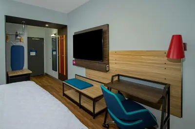 a room with a bed and a desk and a tv at Tru By Hilton Columbus Airport in Columbus